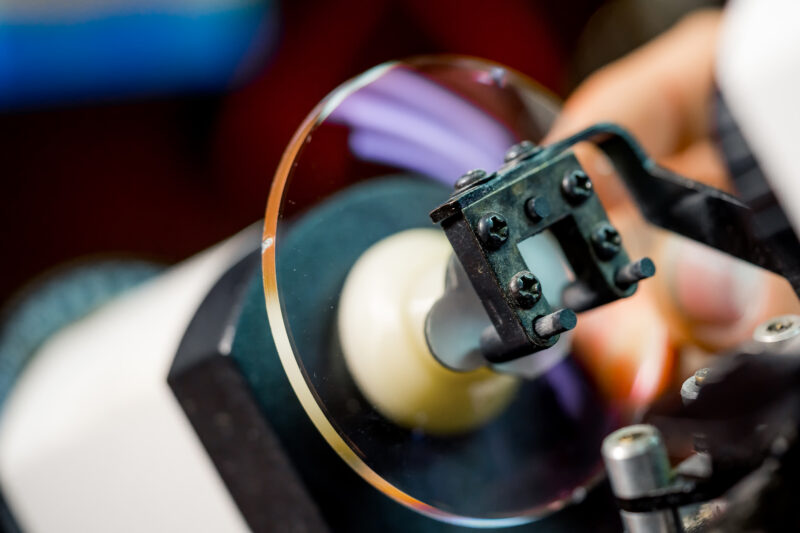 Ophthalmic lens finishing process in optical lab showing polishing and quality control of prescription lenses