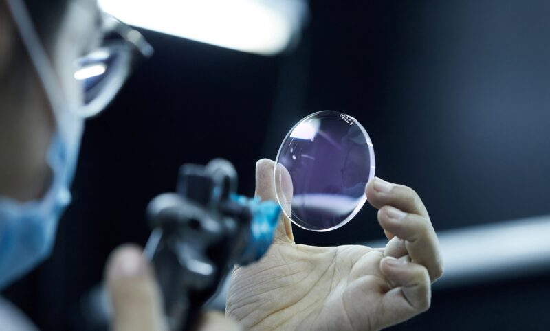 Optical technician measuring prescription lens for digital freeform progressive lens fitting