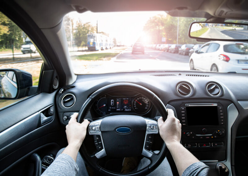 How a laminated windshield blocks 98–99% of UV, the reason driving photochromic lenses barely darken behind the wheel