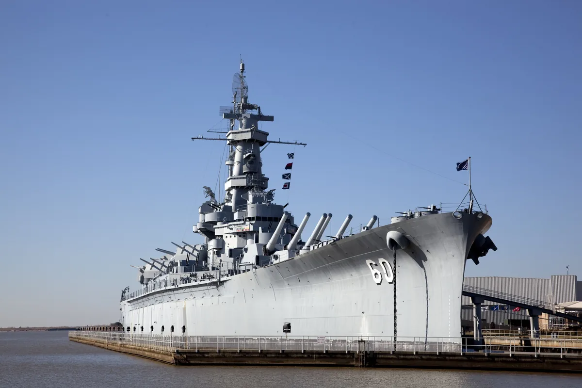 Battleship USS Alabama, hull number 60, moored on Mobile Bay under a clear blue sky