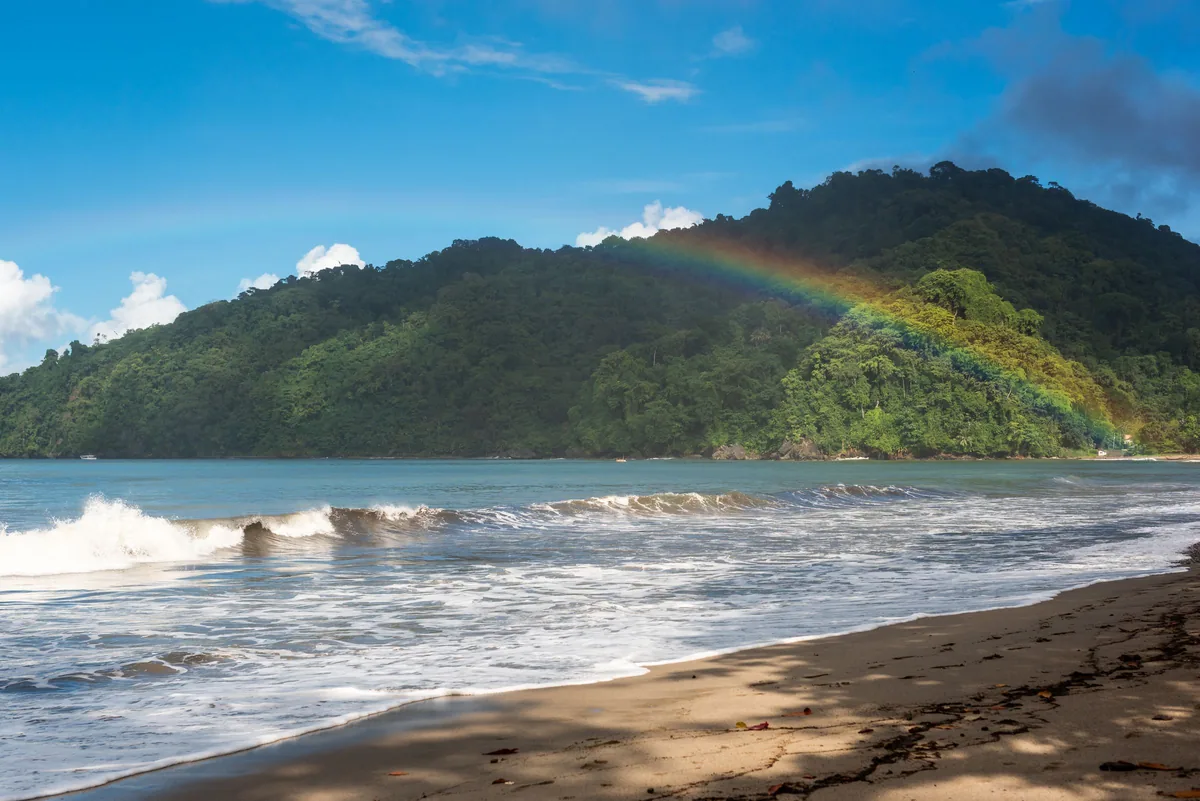 Rainbow over green hills above a beach in Trinidad and Tobago